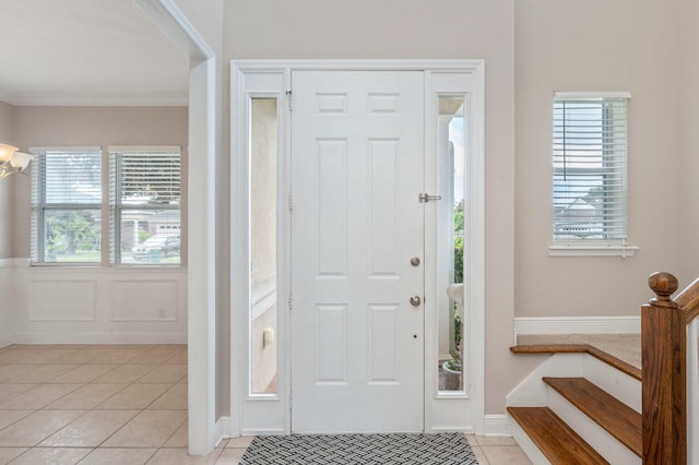 foyer featuring ornamental molding and light tile patterned flooring