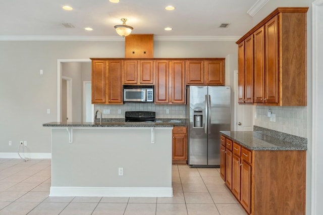 kitchen featuring appliances with stainless steel finishes, tasteful backsplash, a kitchen island with sink, and light tile patterned floors