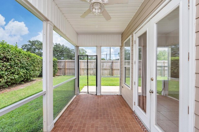 unfurnished sunroom with ceiling fan