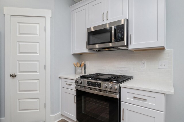 kitchen featuring appliances with stainless steel finishes, white cabinets, and tasteful backsplash