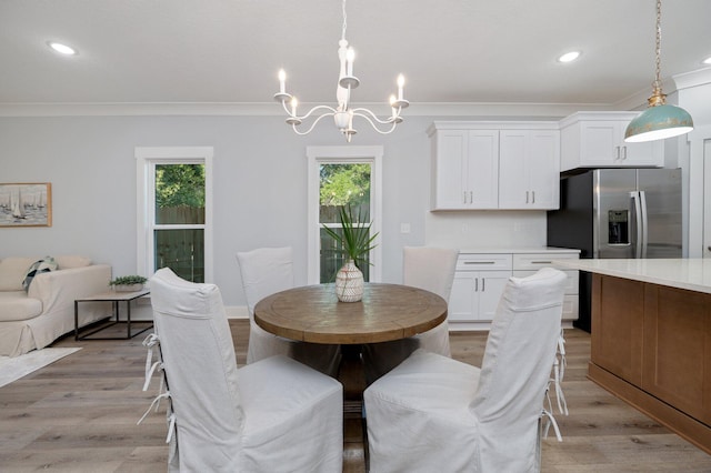 dining space with light wood-type flooring, an inviting chandelier, ornamental molding, and recessed lighting