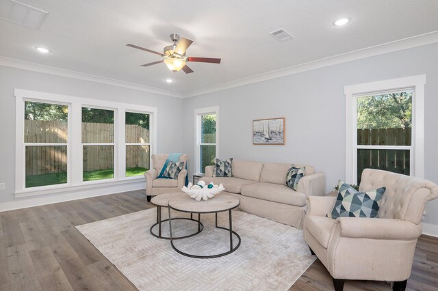 living room featuring recessed lighting, wood finished floors, visible vents, and crown molding