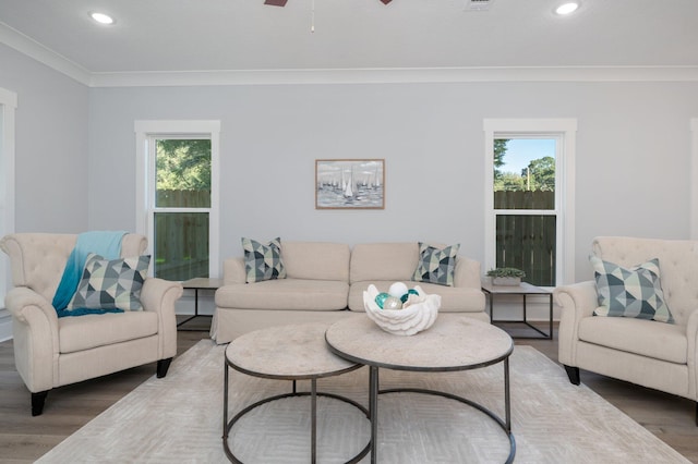 living room with recessed lighting, a healthy amount of sunlight, crown molding, and wood finished floors