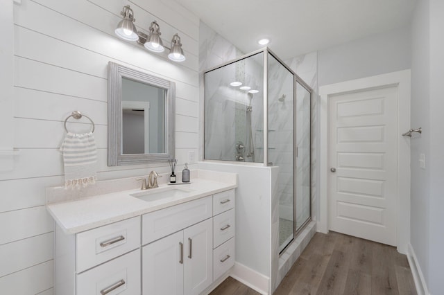 full bath with a shower stall, wood finished floors, and vanity