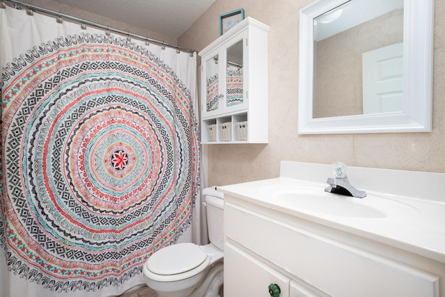 bathroom featuring a textured ceiling, vanity, and toilet