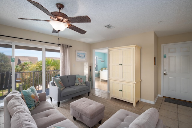 tiled living room with a textured ceiling and ceiling fan