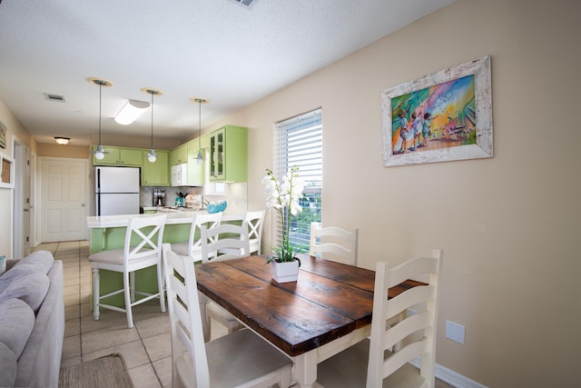 dining room featuring light tile patterned flooring and a textured ceiling