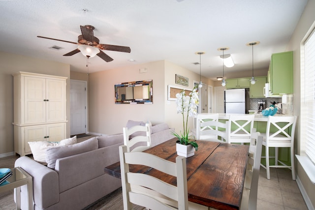 tiled dining area featuring ceiling fan