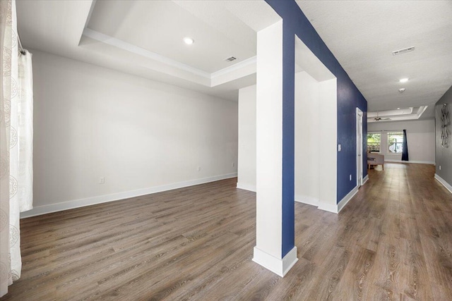 interior space with a raised ceiling and hardwood / wood-style floors