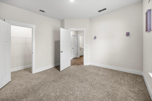 unfurnished bedroom featuring light carpet and a closet