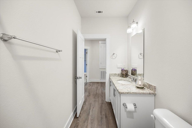 bathroom featuring hardwood / wood-style floors, toilet, and vanity