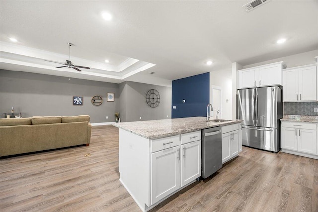 kitchen with light hardwood / wood-style flooring, white cabinets, ceiling fan, stainless steel appliances, and a raised ceiling