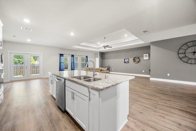 kitchen featuring a raised ceiling, light hardwood / wood-style flooring, sink, and ceiling fan