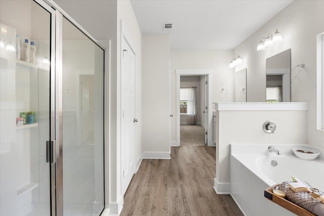 bathroom featuring separate shower and tub and wood-type flooring