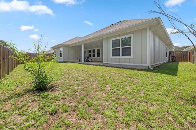 back of house featuring a patio and a lawn