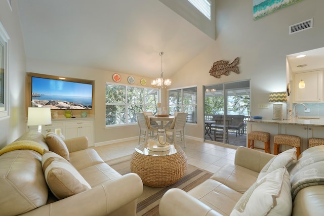 tiled living room with sink, a wealth of natural light, a chandelier, and high vaulted ceiling