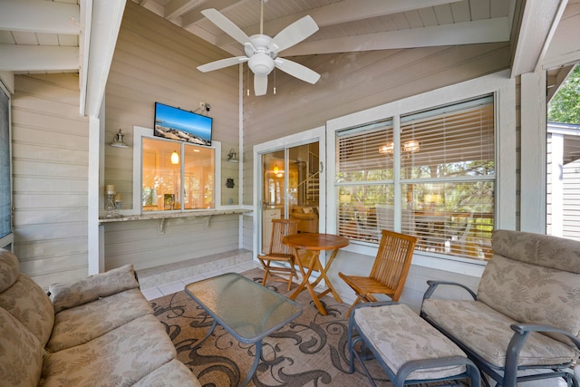 sunroom with ceiling fan and vaulted ceiling with beams