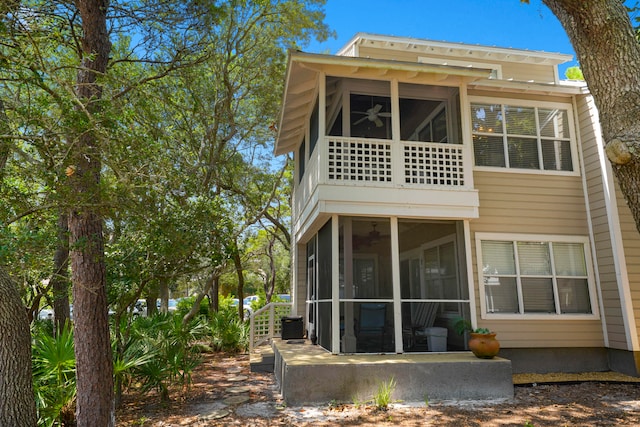 rear view of property featuring a balcony and a sunroom