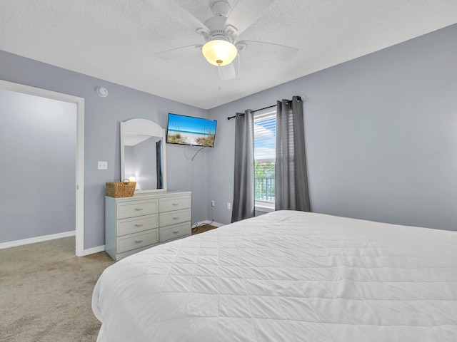 bedroom with a ceiling fan, light carpet, a textured ceiling, and baseboards