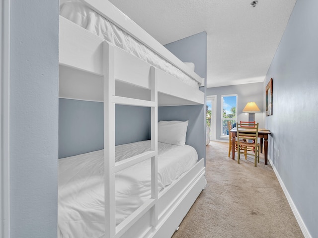 carpeted bedroom with a textured ceiling and baseboards