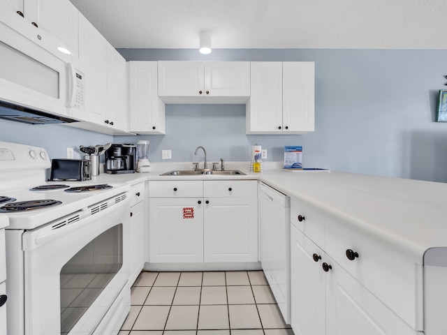 kitchen with white appliances, a peninsula, light countertops, white cabinetry, and a sink