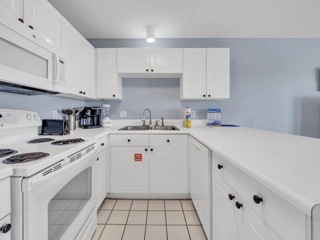 kitchen featuring white appliances, light countertops, a sink, and white cabinetry