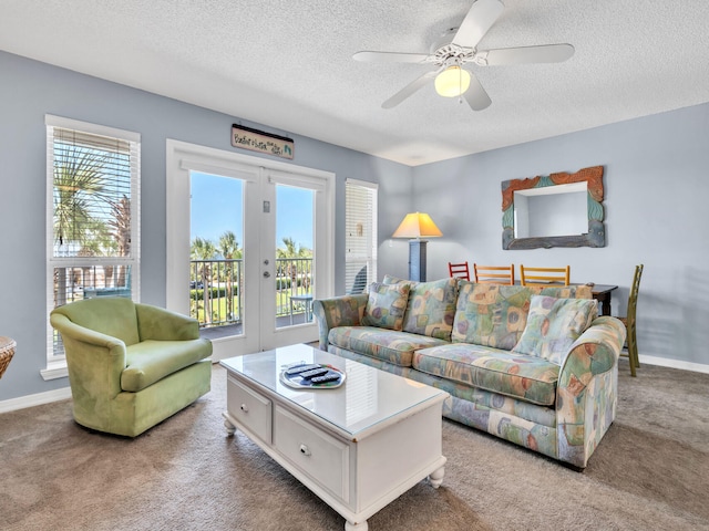 living area featuring a textured ceiling, a ceiling fan, baseboards, french doors, and carpet