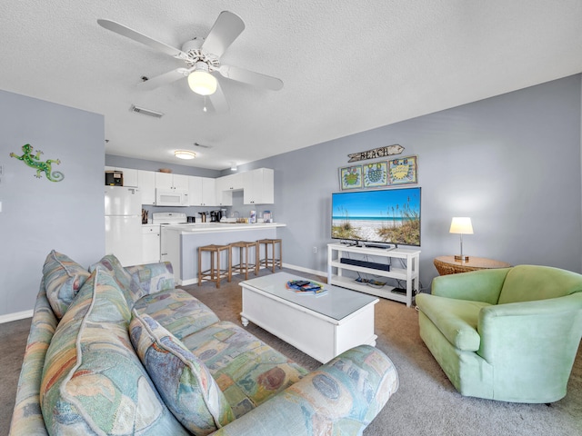 living area featuring visible vents, a ceiling fan, carpet flooring, a textured ceiling, and baseboards