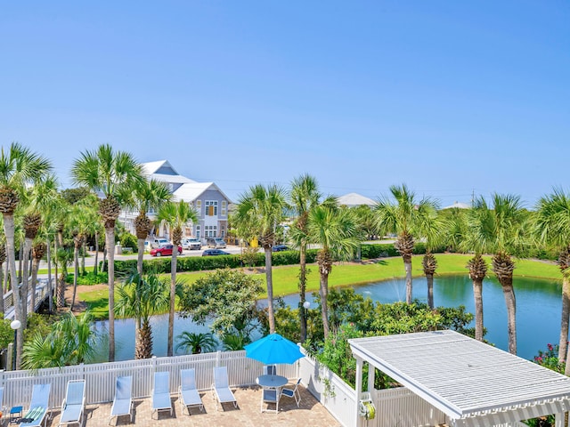 dock area featuring a water view, fence, and a patio