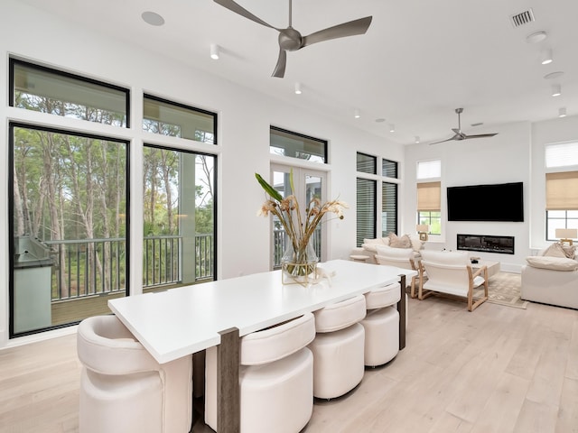 dining area with light wood-type flooring and ceiling fan