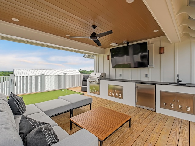 view of patio / terrace with an outdoor living space, a deck, ceiling fan, grilling area, and sink