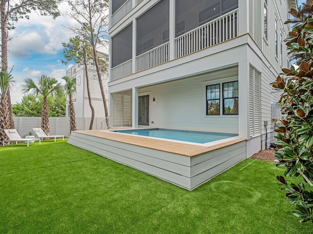 rear view of property featuring a yard and a balcony