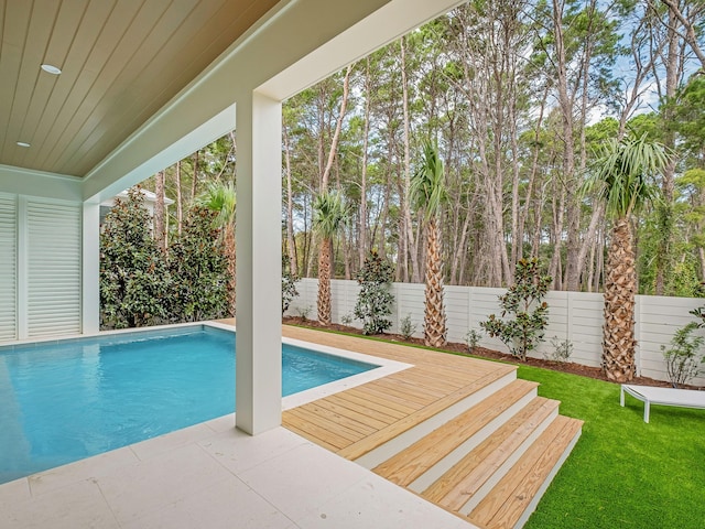 view of pool with a wooden deck and a yard