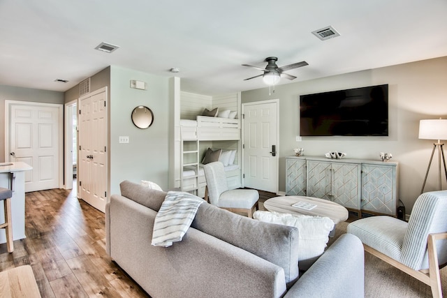 living room featuring wood-type flooring and ceiling fan