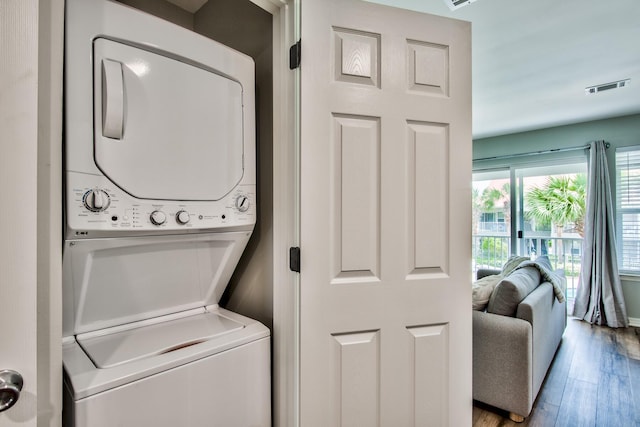 laundry area featuring light hardwood / wood-style flooring and stacked washing maching and dryer