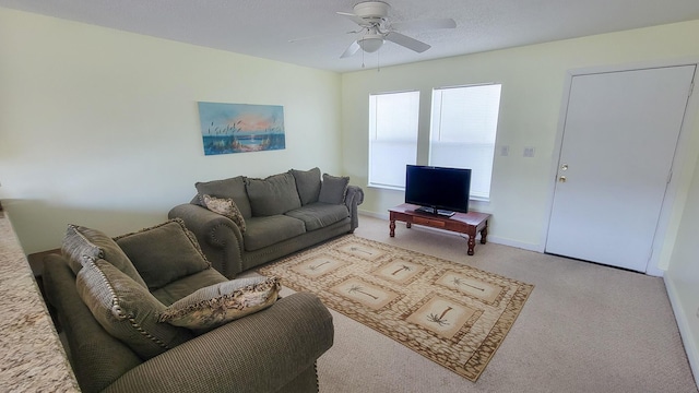 living area with carpet floors, ceiling fan, and baseboards