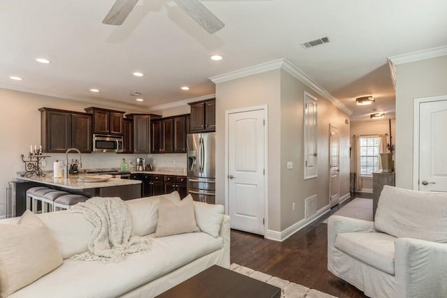 living room with ornamental molding, sink, ceiling fan, and dark wood-type flooring