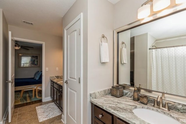 bathroom with tile patterned flooring, vanity, and ceiling fan