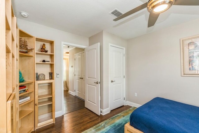 bedroom with ceiling fan and dark wood-type flooring