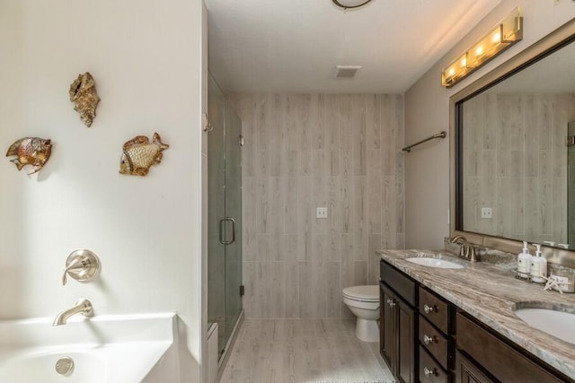 full bathroom with toilet, shower with separate bathtub, dual bowl vanity, and tile walls