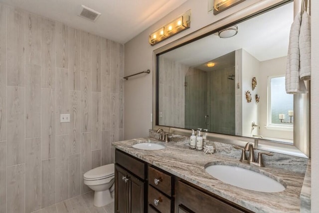 bathroom with tile patterned flooring, dual vanity, and toilet