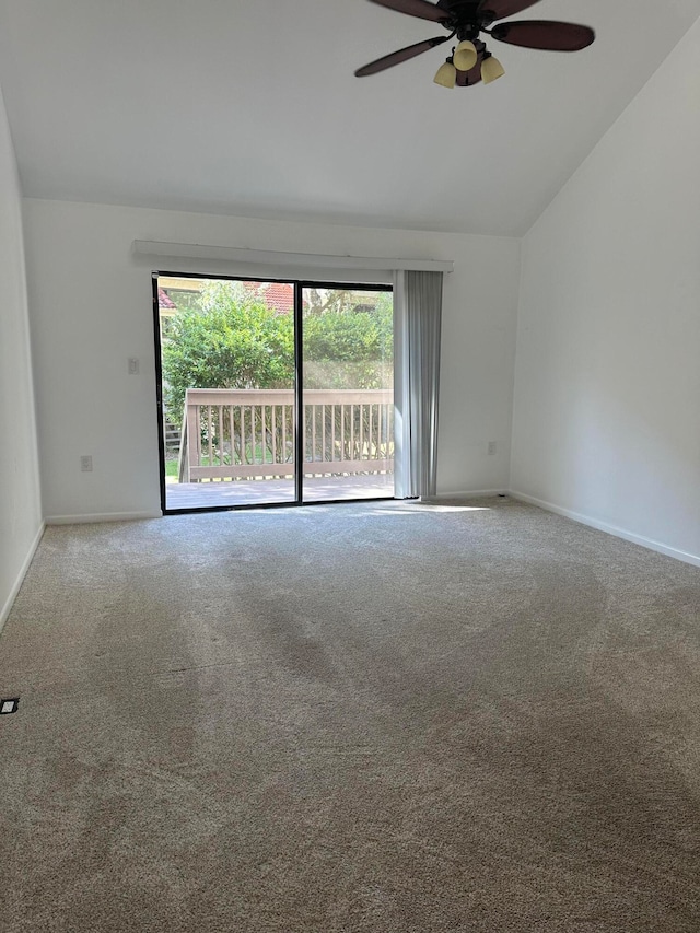 spare room featuring carpet, vaulted ceiling, and ceiling fan