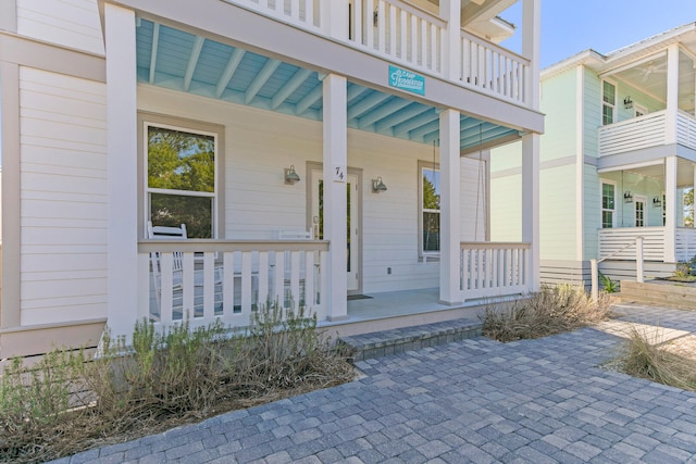 doorway to property featuring a balcony and covered porch