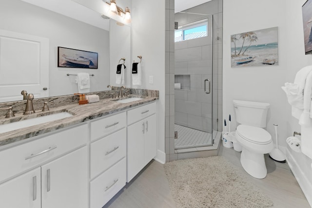 bathroom with walk in shower, vanity, and toilet