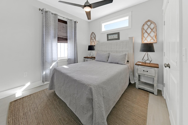 bedroom featuring multiple windows, hardwood / wood-style floors, and ceiling fan