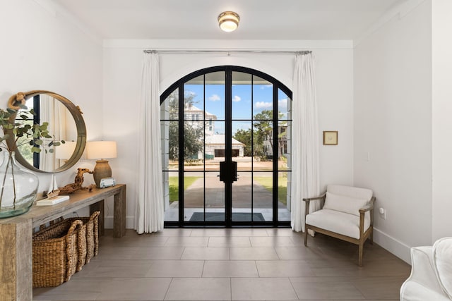 doorway with tile patterned floors, french doors, and ornamental molding