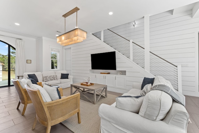 living room featuring crown molding and light hardwood / wood-style floors