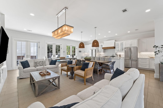 tiled living room featuring sink, crown molding, and french doors