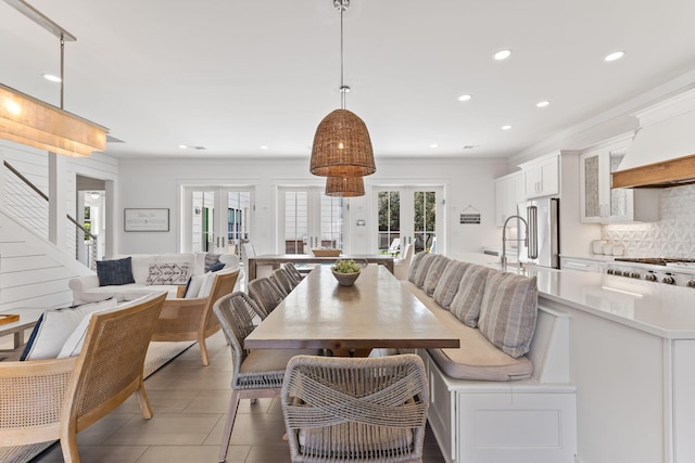 tiled dining space featuring french doors and ornamental molding