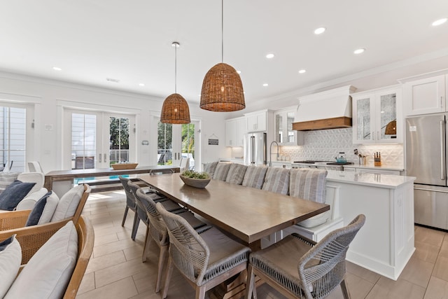 dining space featuring french doors, crown molding, and sink